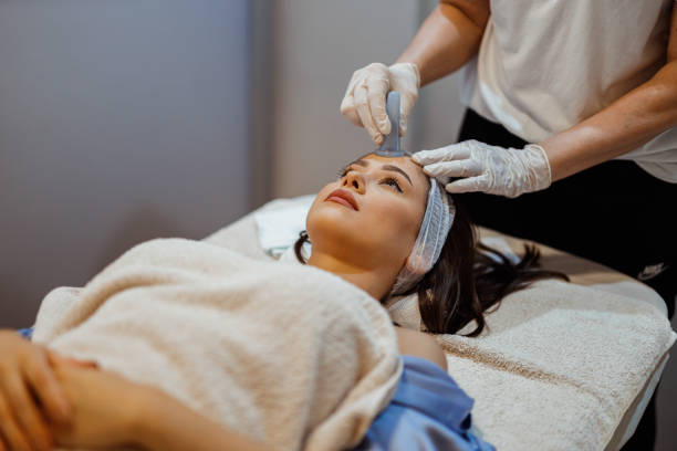Beautiful young woman lying down in the beauty clinic and having a facial cupping massage treatment to stimulate blood circulation